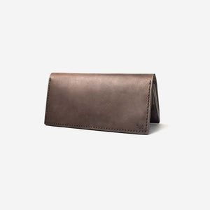 a dark brown leather wallet with hand stitching and etched logo details