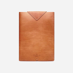 camel brown leather laptop sleeve with white stitching and etched logo details.