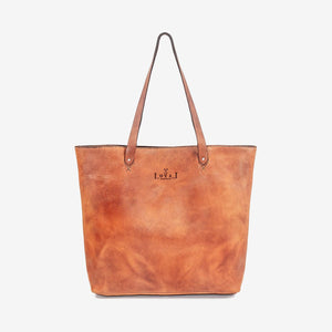 A large caramel brown handmade leather tote bag with hand stitching and etched logo detailing