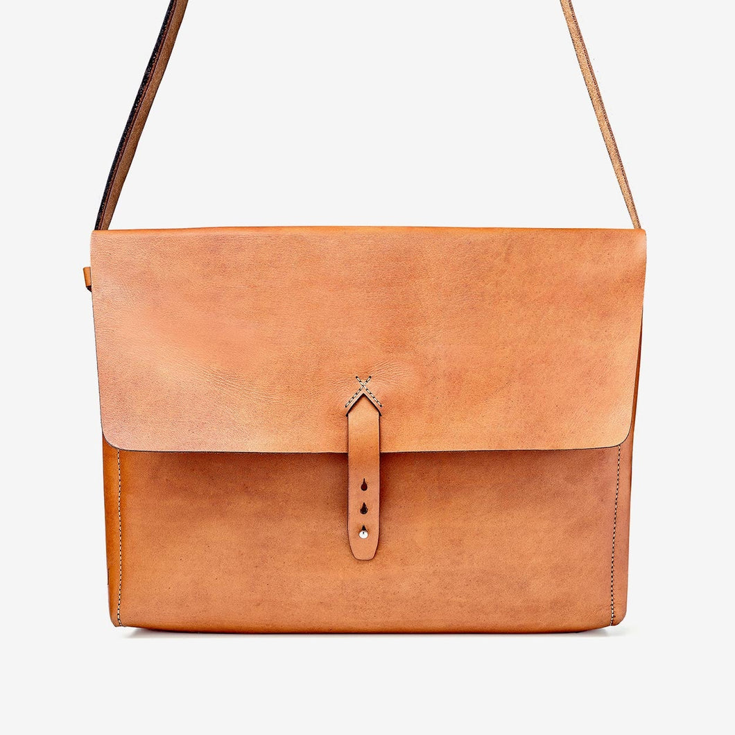 caramel brown leather handbag with hand stitching and brass hardware details.