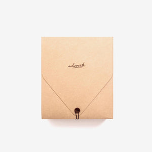 birds eye view of natural brown packaging with etched cursive font and a brown button closure
